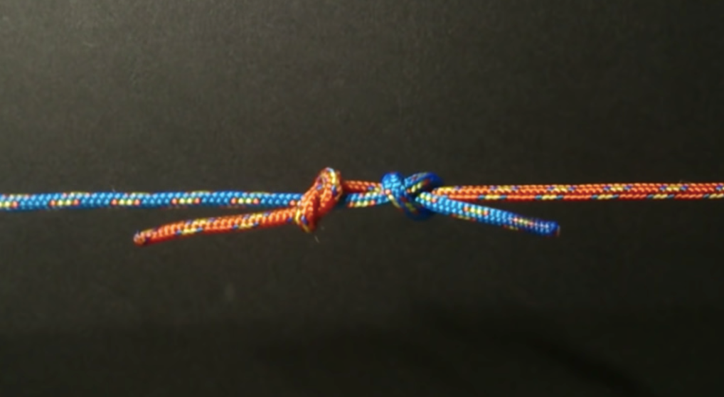 Fishermans knot made from blue and red cord